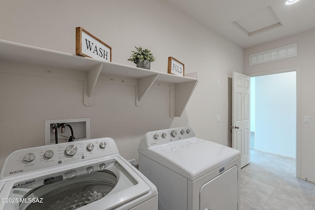 clothes washing area featuring washer and dryer and light tile patterned floors