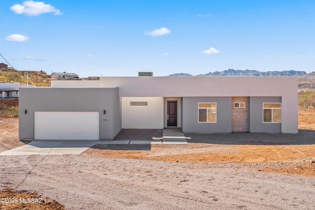 adobe home with a garage and a mountain view