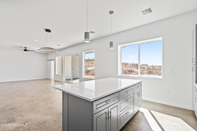 kitchen featuring hanging light fixtures, a kitchen island, plenty of natural light, and gray cabinets