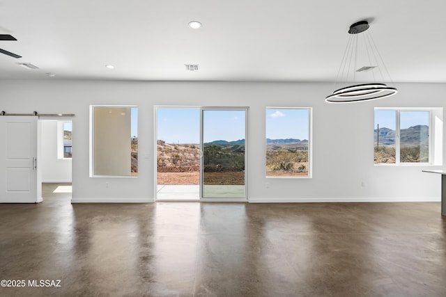 interior space with ceiling fan, a barn door, and a mountain view