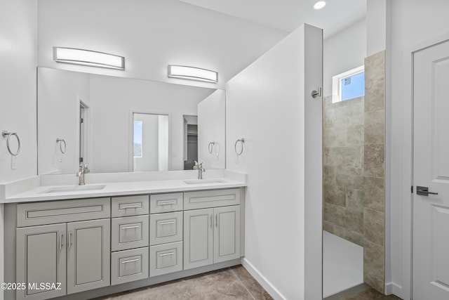 bathroom featuring a tile shower and vanity