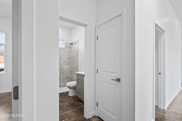 bathroom with vanity, toilet, and a tile shower