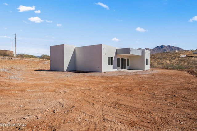 rear view of property with a mountain view and a patio area