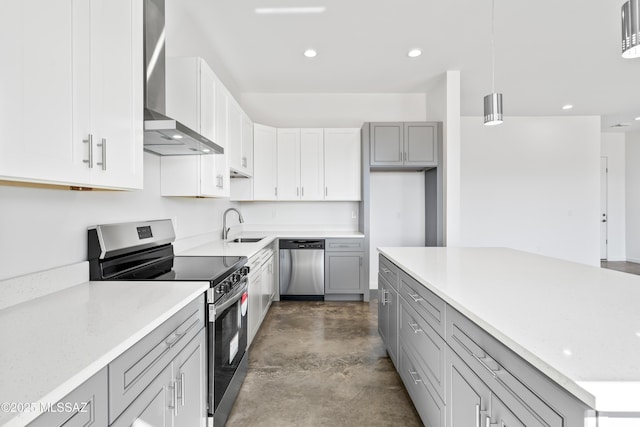 kitchen with wall chimney exhaust hood, sink, hanging light fixtures, appliances with stainless steel finishes, and gray cabinets