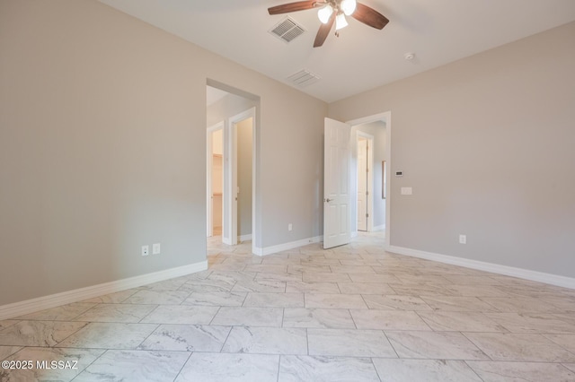 spare room with marble finish floor, ceiling fan, baseboards, and visible vents