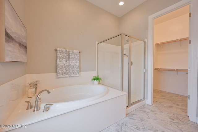 full bath with a garden tub, a spacious closet, recessed lighting, marble finish floor, and a stall shower
