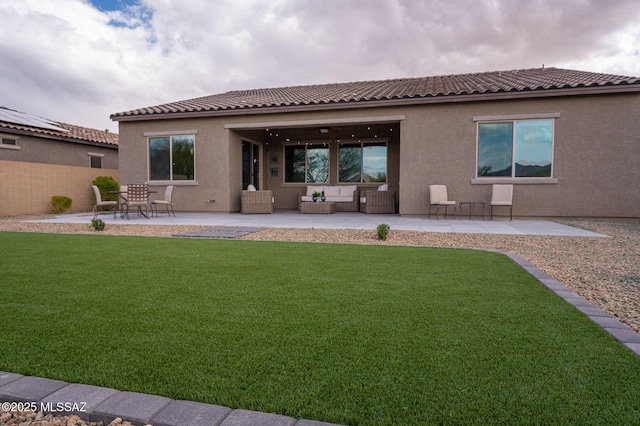 back of house featuring a patio area, stucco siding, a tiled roof, and a yard