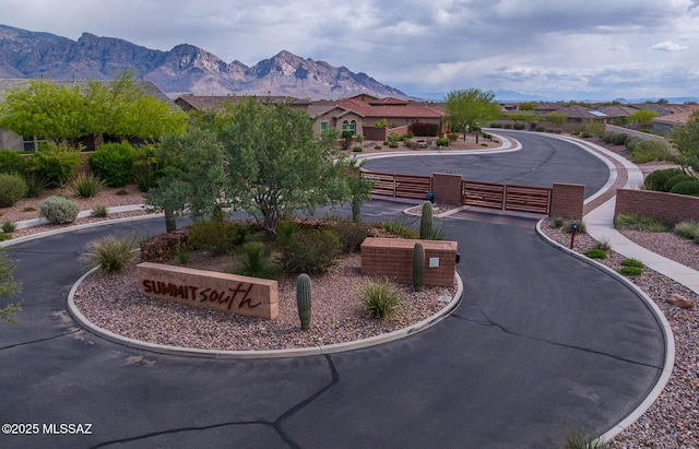 view of home's community featuring fence, a mountain view, and a gate