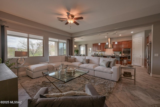 living area featuring baseboards, a ceiling fan, and recessed lighting