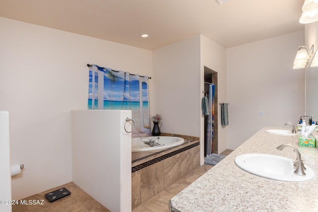 bathroom featuring vanity, tile patterned floors, and tiled bath