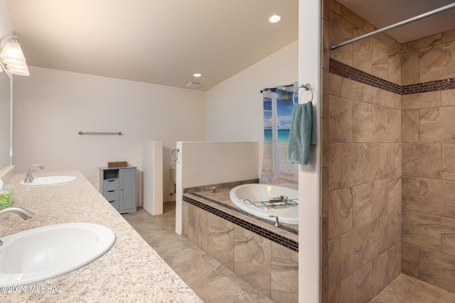 bathroom featuring vanity and tiled tub