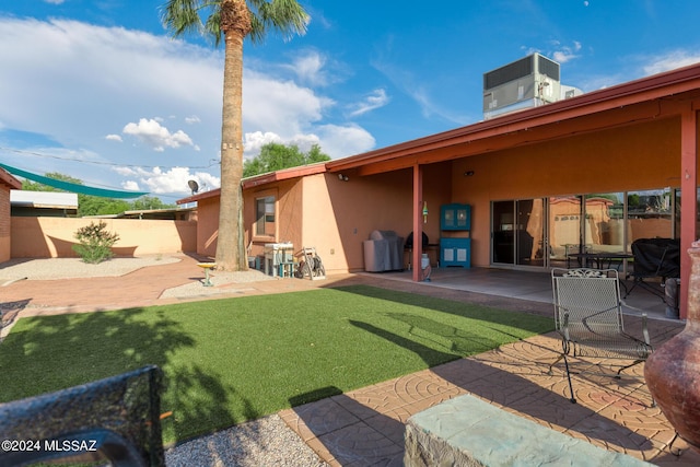 back of property with a patio, a lawn, and central air condition unit