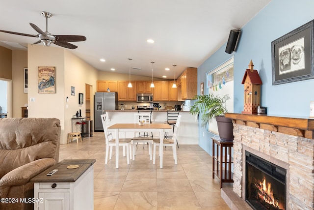 dining area with a fireplace and vaulted ceiling