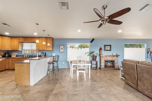 kitchen with a healthy amount of sunlight, a kitchen breakfast bar, sink, and hanging light fixtures