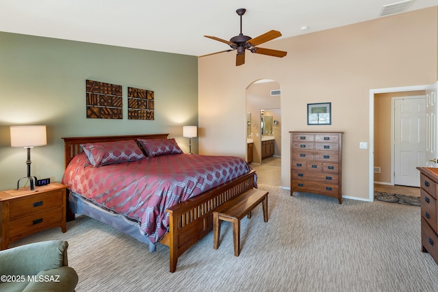 carpeted bedroom with ceiling fan, ensuite bath, and vaulted ceiling