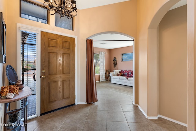 foyer entrance featuring light tile patterned floors and an inviting chandelier