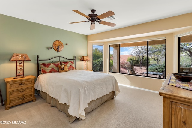 bedroom with ceiling fan, light colored carpet, and multiple windows