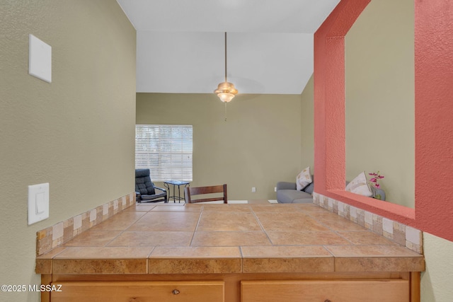 kitchen with lofted ceiling and tile countertops