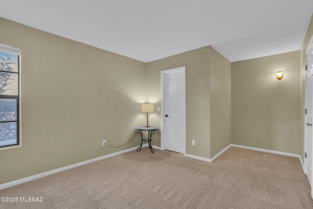 carpeted empty room featuring a textured ceiling