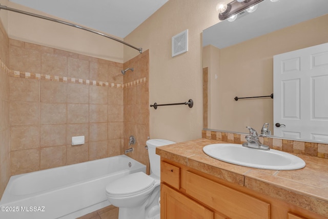 full bathroom featuring tiled shower / bath, vanity, tile patterned floors, and toilet