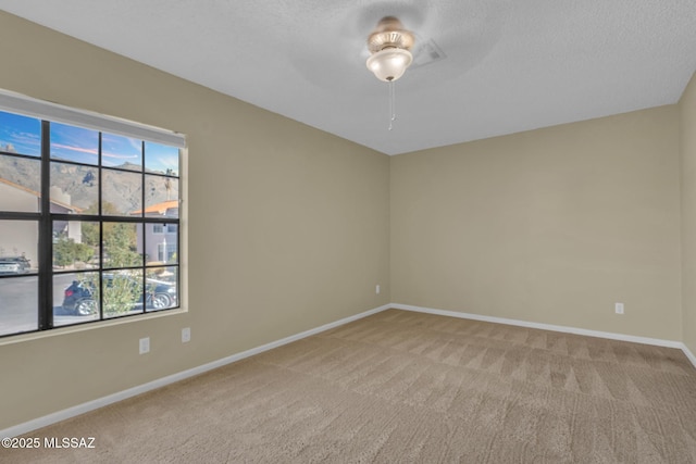 carpeted empty room featuring a textured ceiling