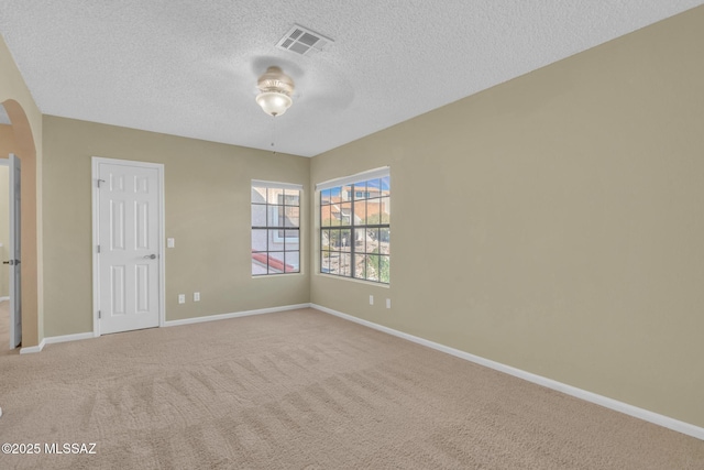 carpeted spare room with ceiling fan and a textured ceiling