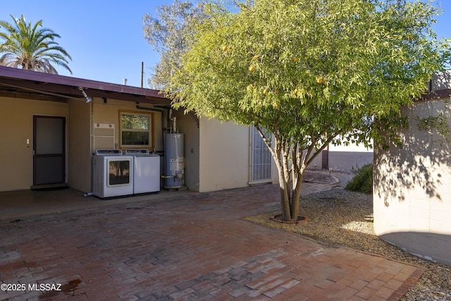 view of patio with independent washer and dryer and gas water heater