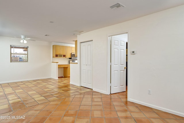 tiled spare room featuring ceiling fan