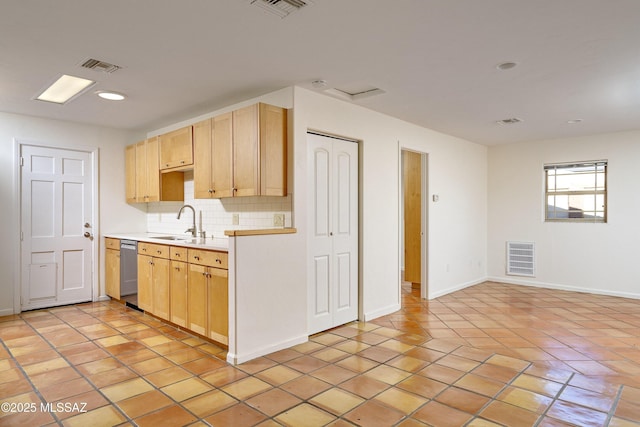 kitchen with sink, light tile patterned floors, light brown cabinets, stainless steel dishwasher, and backsplash