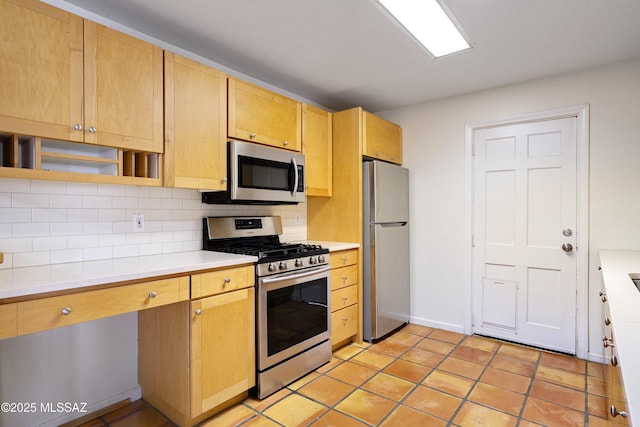 kitchen featuring stainless steel appliances, light brown cabinetry, light tile patterned floors, and backsplash