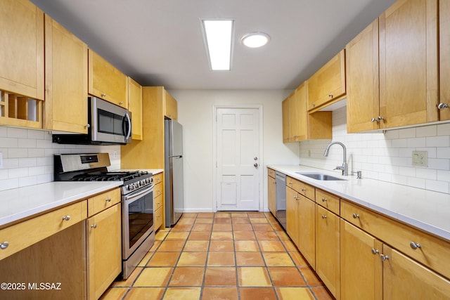 kitchen featuring tasteful backsplash, appliances with stainless steel finishes, sink, and light tile patterned floors