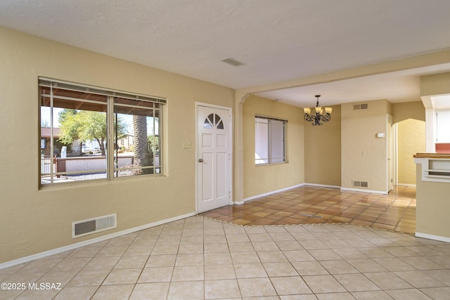 tiled foyer with an inviting chandelier