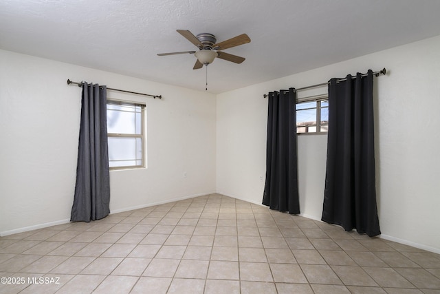 empty room with light tile patterned floors and ceiling fan