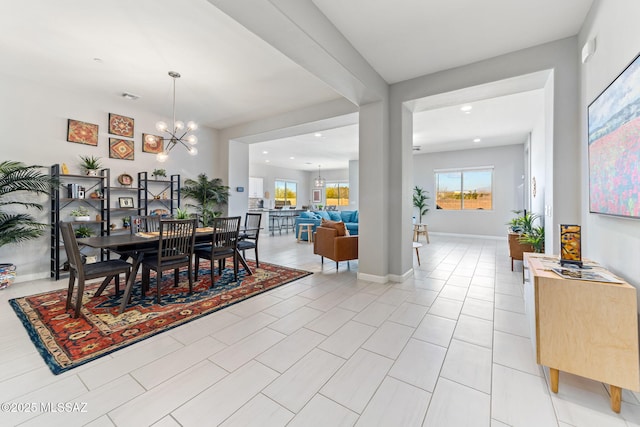 tiled dining room featuring a chandelier