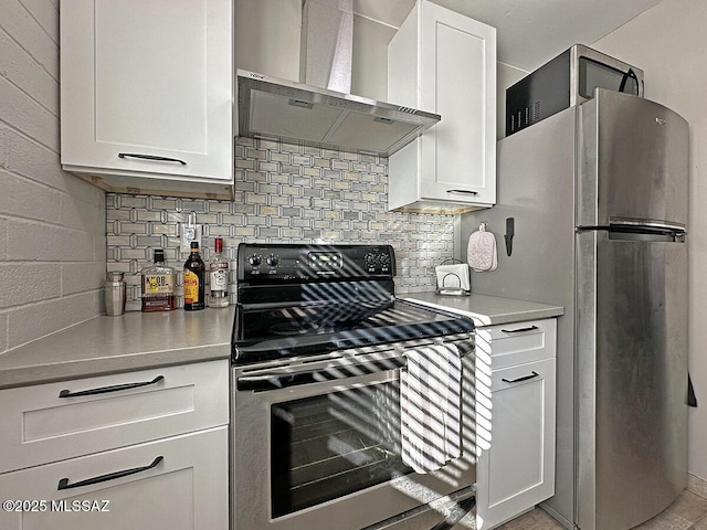 kitchen featuring tasteful backsplash, white cabinets, stainless steel appliances, and wall chimney range hood