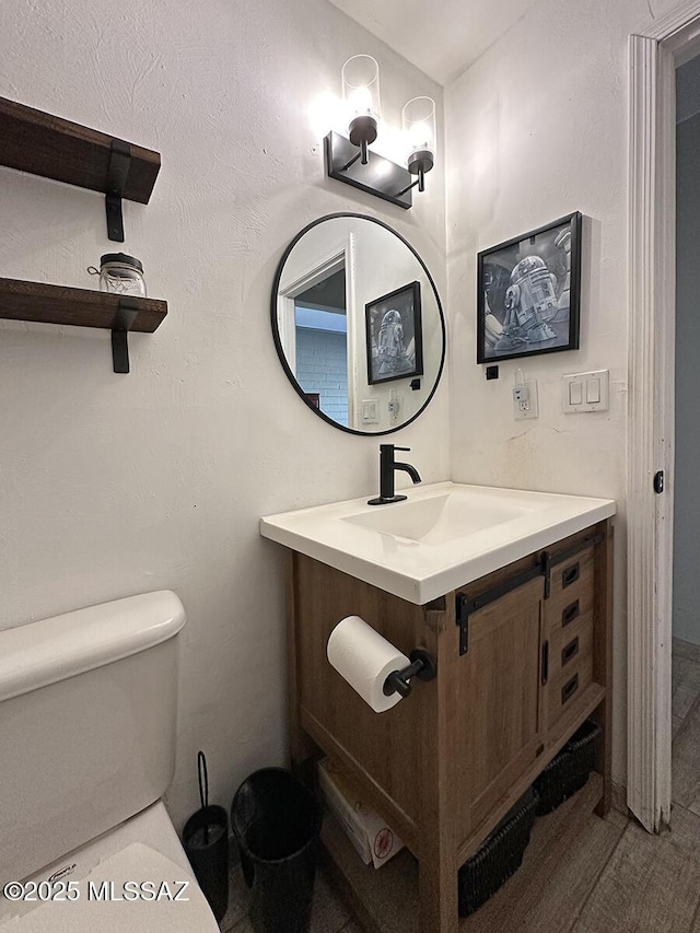 bathroom featuring vanity and toilet