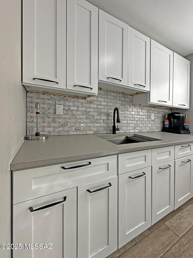 kitchen with white cabinetry, sink, and backsplash