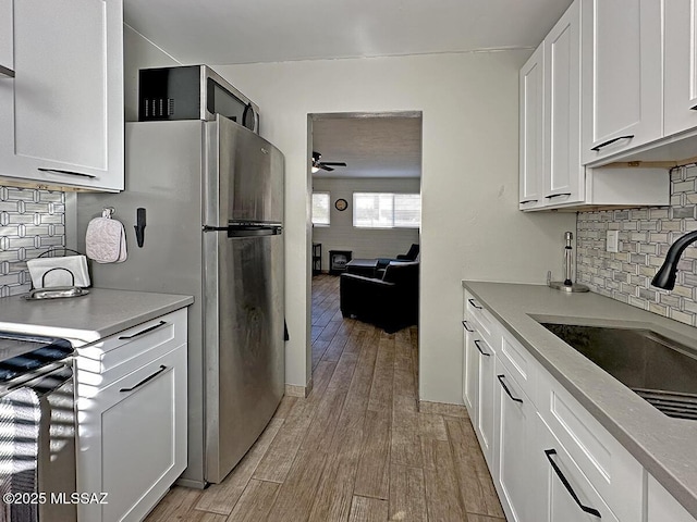 kitchen with white cabinetry, sink, backsplash, and ceiling fan