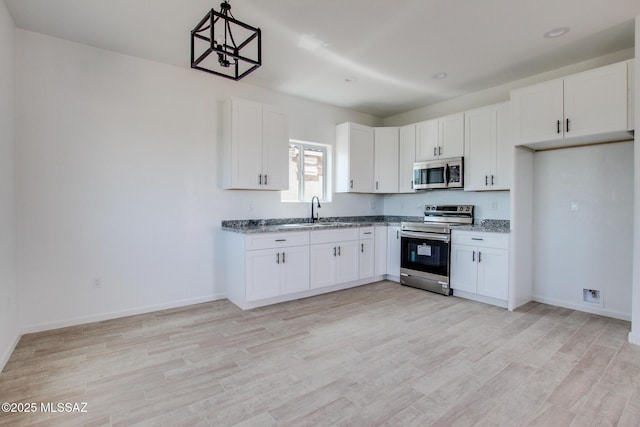 kitchen with white cabinetry, appliances with stainless steel finishes, and light wood-type flooring