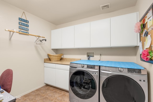 clothes washing area featuring cabinet space, baseboards, visible vents, and washer and clothes dryer