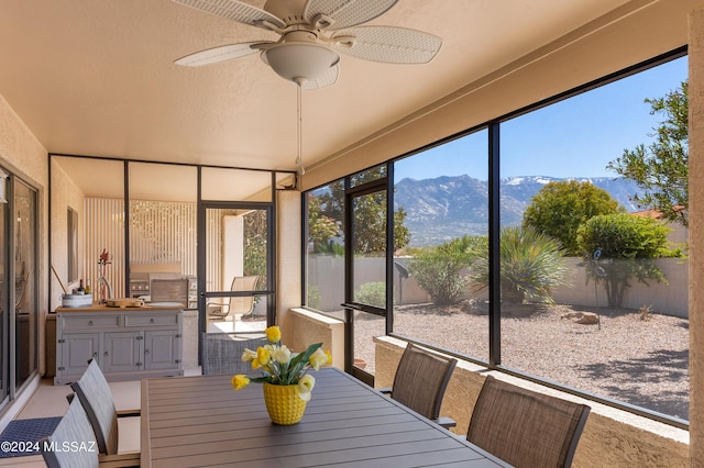 sunroom featuring a mountain view and a ceiling fan