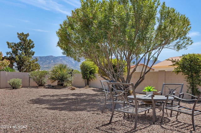 view of yard with a fenced backyard, a mountain view, and a patio