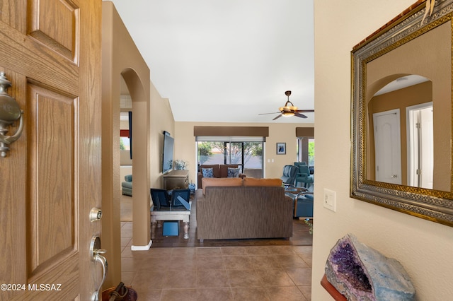 foyer entrance featuring tile patterned flooring, arched walkways, and ceiling fan