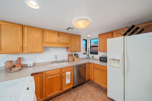 kitchen featuring dishwasher, sink, white fridge with ice dispenser, range, and a textured ceiling