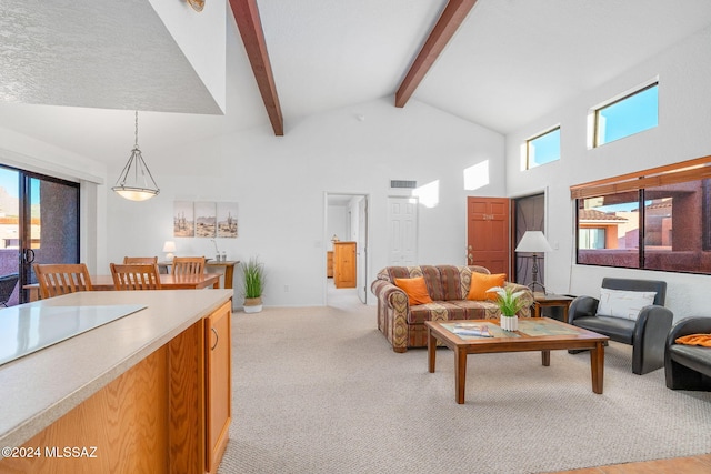 carpeted living room with high vaulted ceiling and beamed ceiling