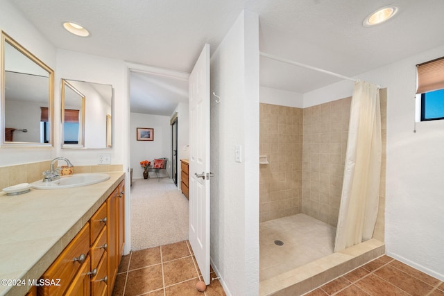 bathroom featuring tile patterned flooring, vanity, and walk in shower