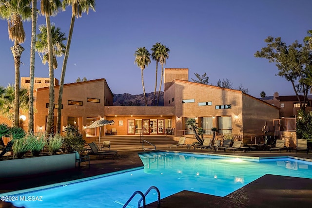 pool at dusk featuring a patio