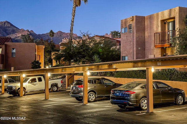 parking at dusk with a carport and a mountain view