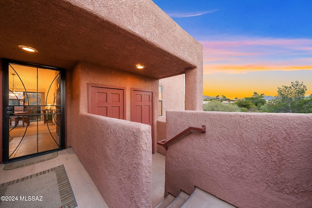 exterior entry at dusk featuring a balcony