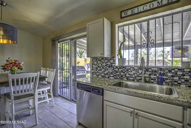 kitchen with tasteful backsplash, dishwasher, white cabinetry, and a sink